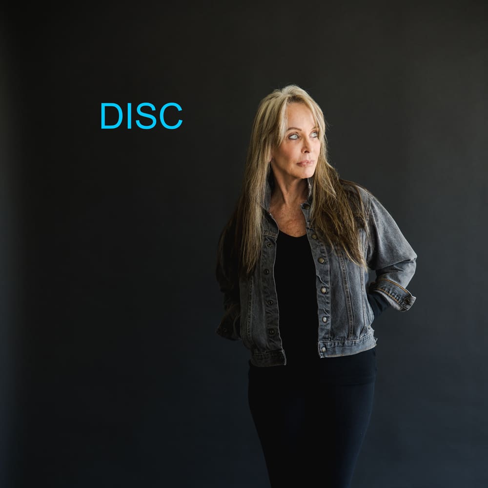 A woman standing in front of a black wall.