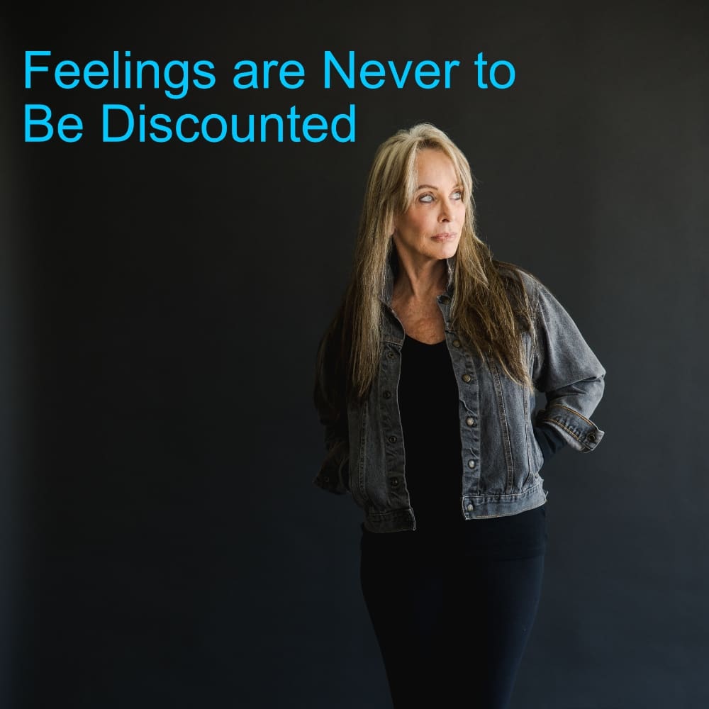 A woman standing in front of a black wall.