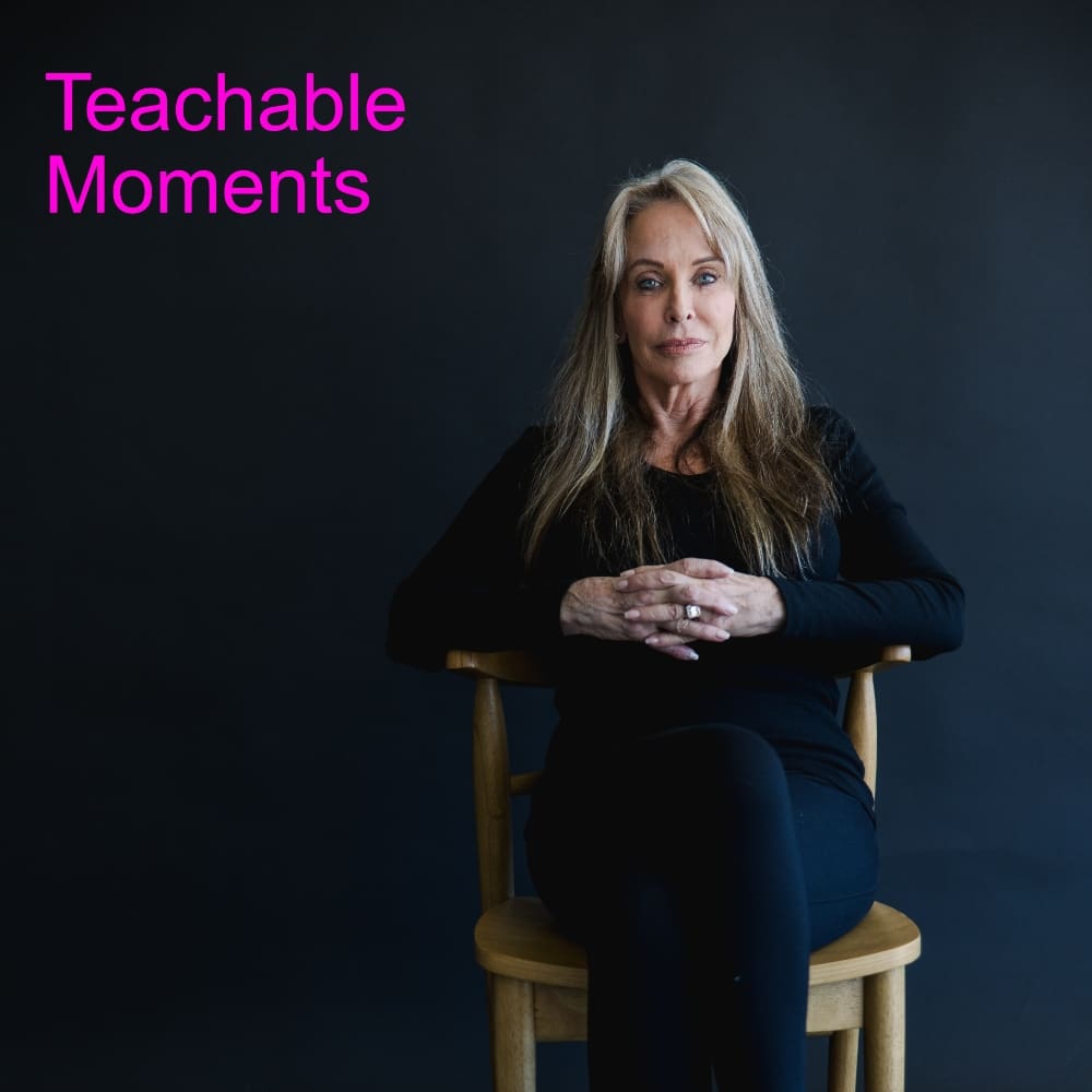 A woman sitting in a chair with her hands crossed.