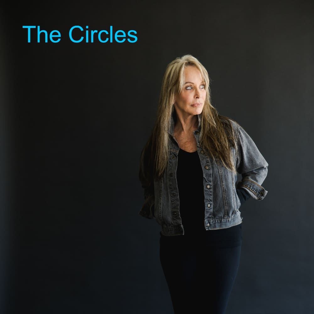 A woman standing in front of a black wall.