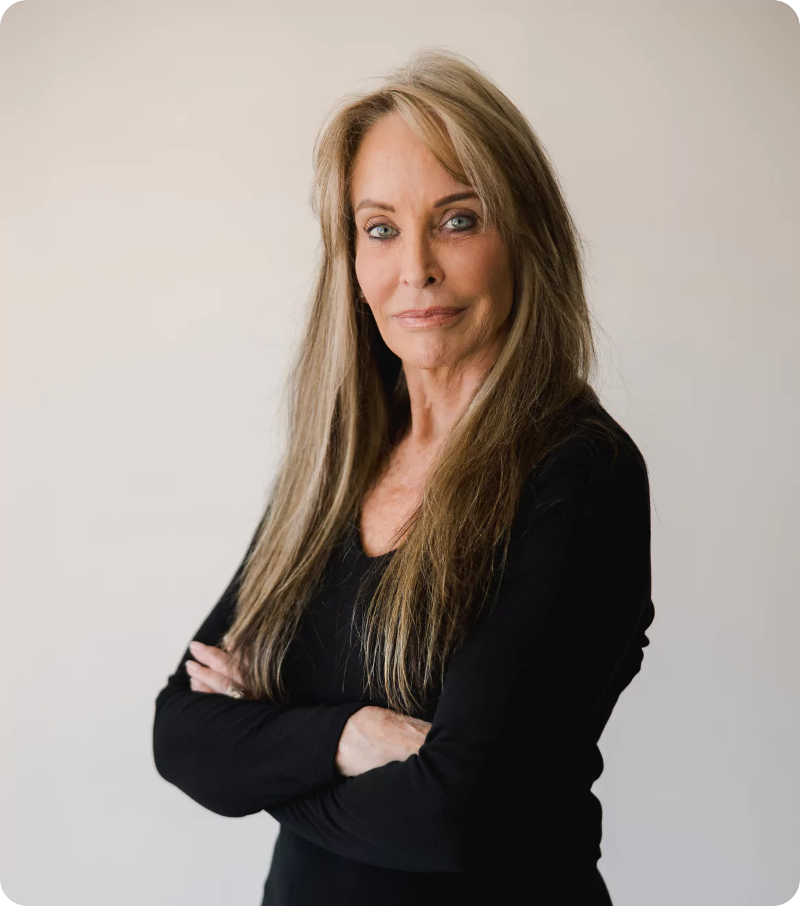 A woman with long hair and arms crossed.